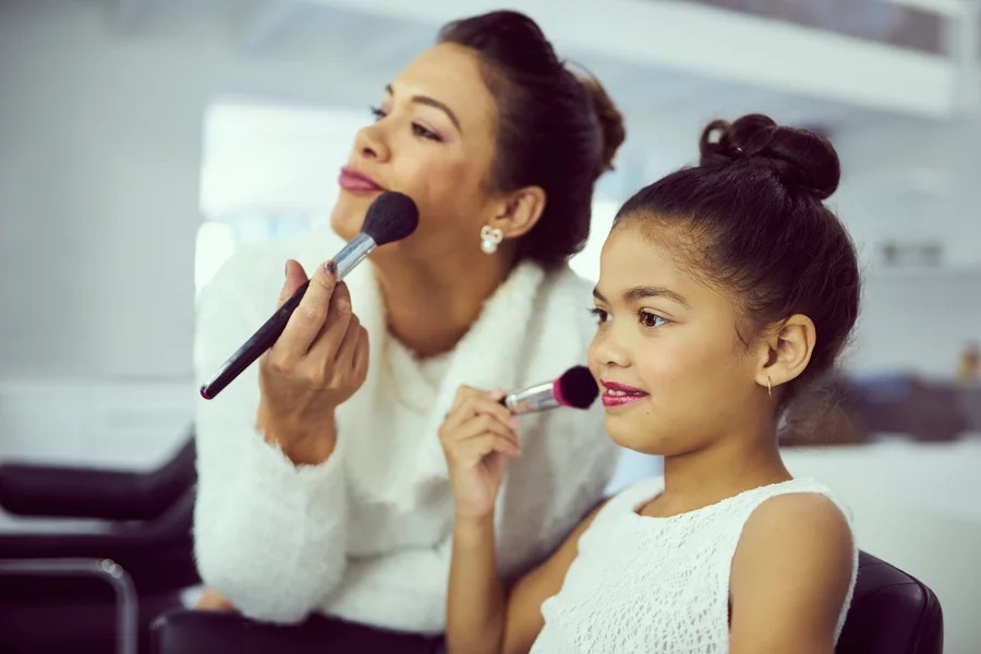 A mother uses her own makeup brushes with daughter, just one object in a beauty pageant starter pack.